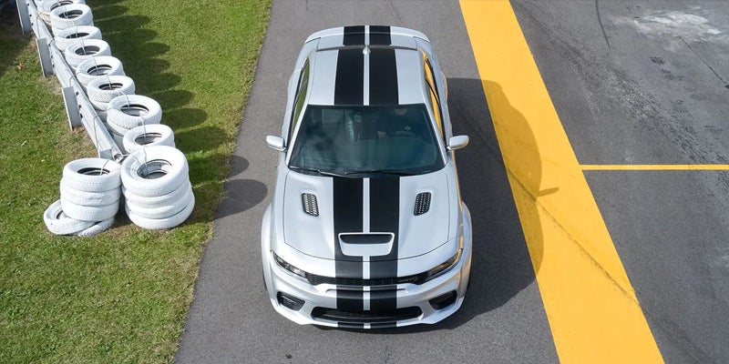 A white car with black lines parked near lawn
